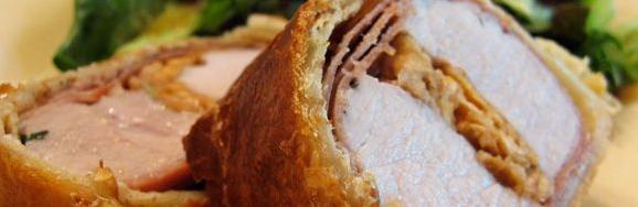  A golden brown wellington filled with savory pork and leeks.