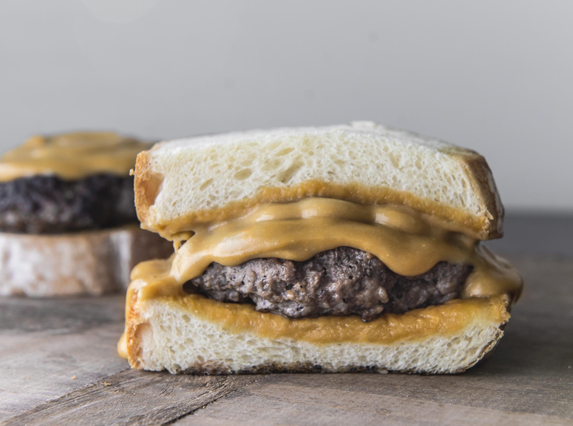  Juicy beef patties, slathered in melted Welsh rarebit, and served on a soft bun.